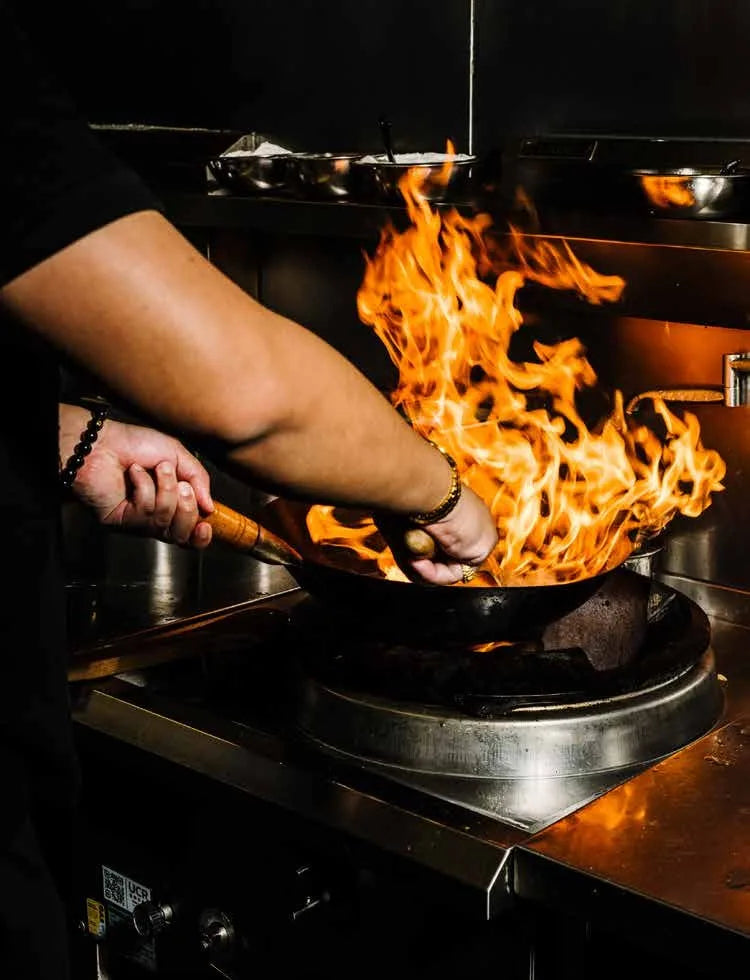 Wok tossing over open flame